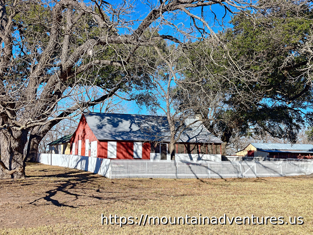 House and Barn with Trees and White Picket Fence