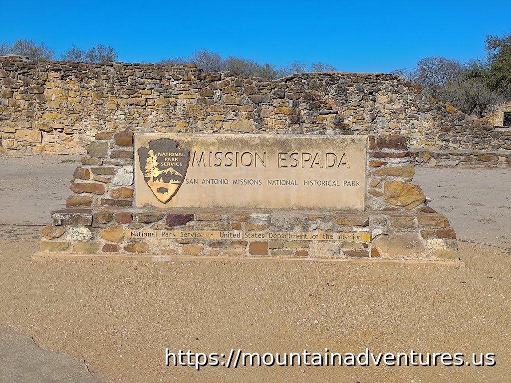 Entrance Sign in Front of a Mission Wall